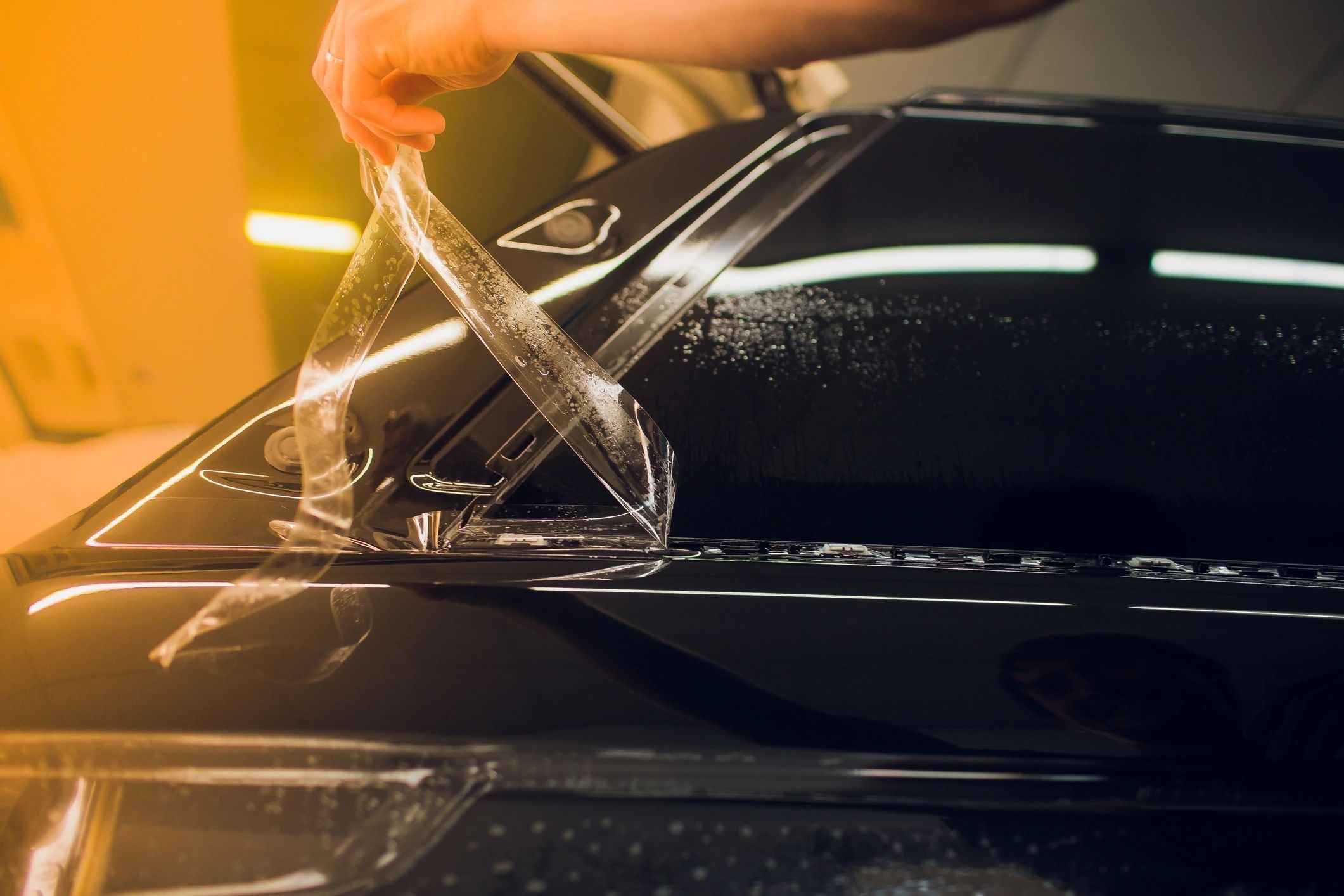Technician applying paint protection film to vehicle hood at Tint Citi Utah